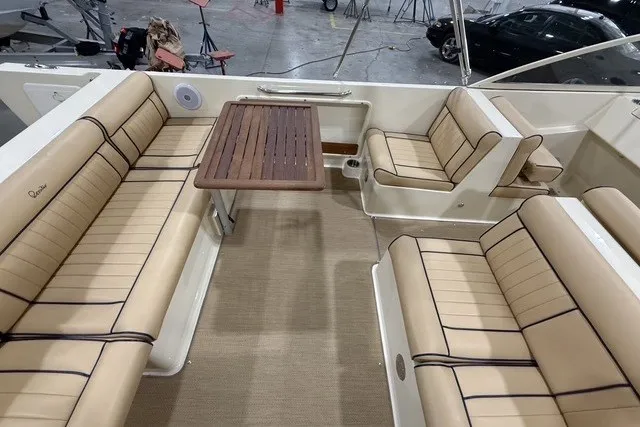 Slide: The Image of Luxurious seating area on a 2023 Rossiter 23 boat with beige cushions and wooden table. - 8