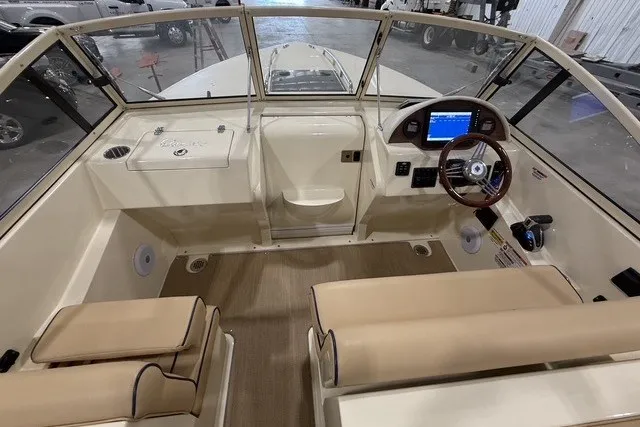 Slide: The Image of 2023 Rossiter 23 boat interior with beige seating and modern dashboard controls. - 11