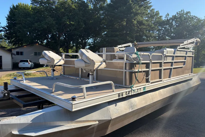 Slide: The Image of 1984 Ercoa Captain 21 pontoon boat with seating, parked outdoors on a sunny day. - 3