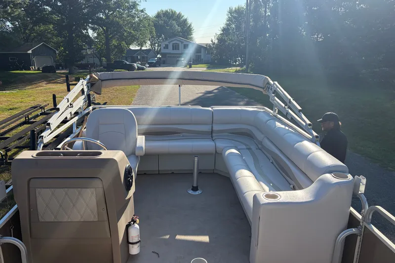 Slide: The Image of 1984 Ercoa Captain 21 pontoon boat with spacious seating and steering console, parked outdoors. - 5