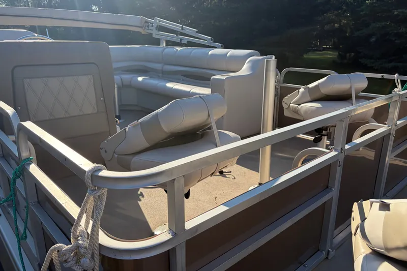Slide: The Image of 1984 Ercoa Captain 21 pontoon boat interior with seating and railing in sunlight. - 2
