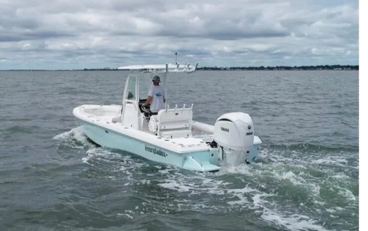 The Image of 2022 Everglades 243 Center Console boat cruising on open water under cloudy skies. - 2