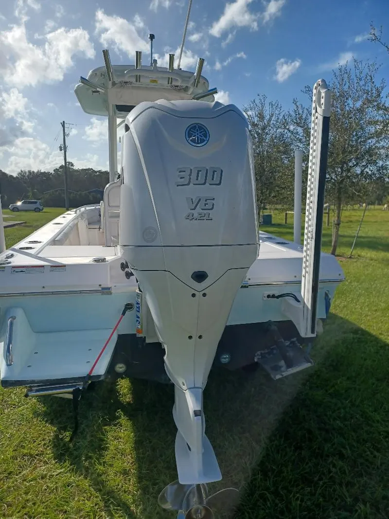 Slide: The Image of 2022 Everglades 243 Center Console boat with 300 V6 engine, parked on grass. - 30