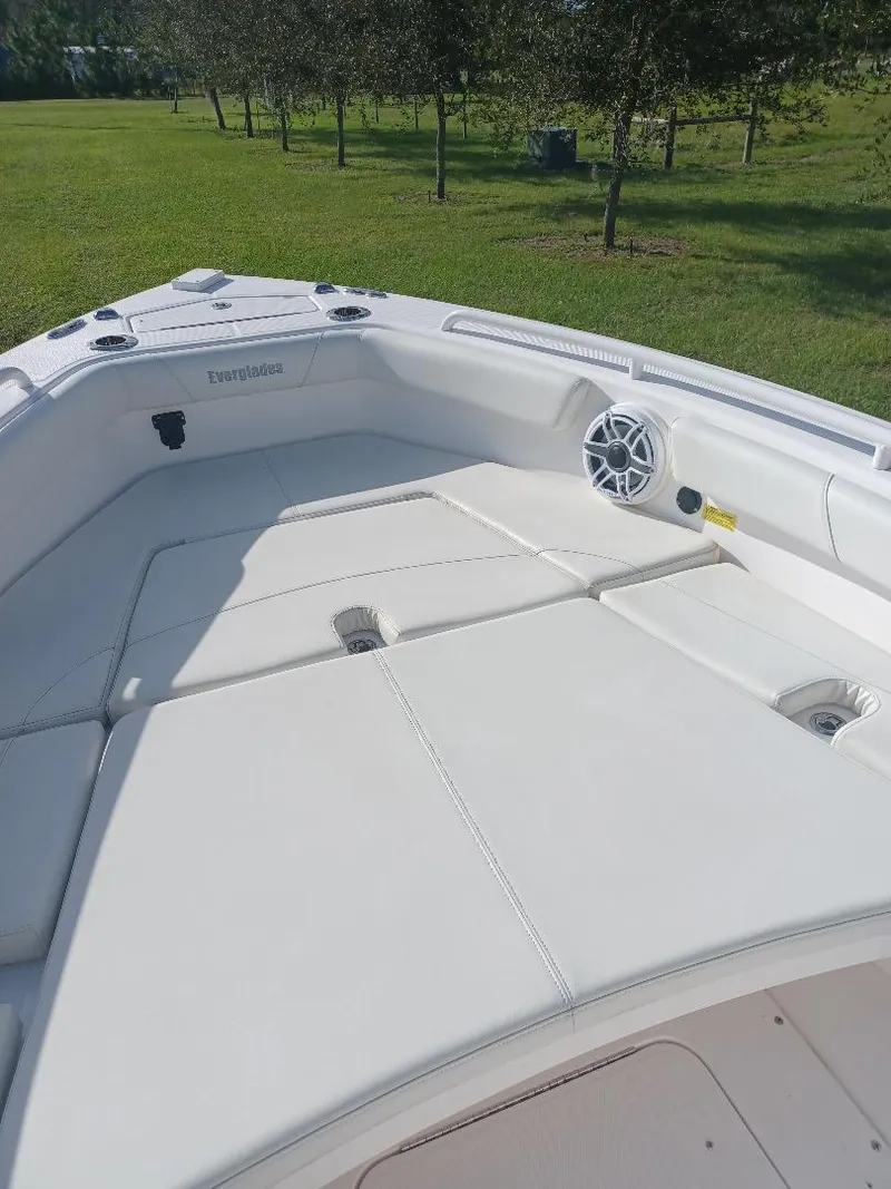 Slide: The Image of 2022 Everglades 243 Center Console boat with spacious deck and seating, set in a grassy area. - 23