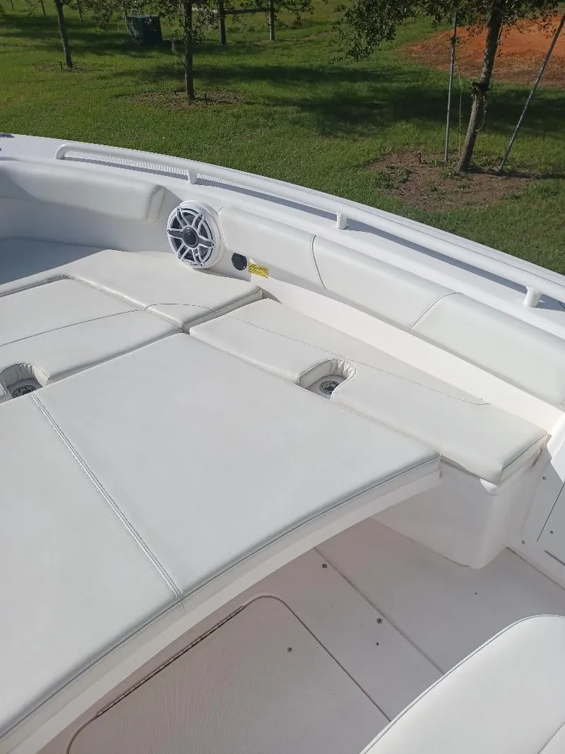 Slide: The Image of 2022 Everglades 243 Center Console boat with white cushioned seating and speaker. - 25