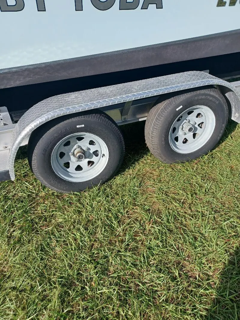 Slide: The Image of Trailer wheels of a 2022 Everglades 243 Center Console on grass. - 34