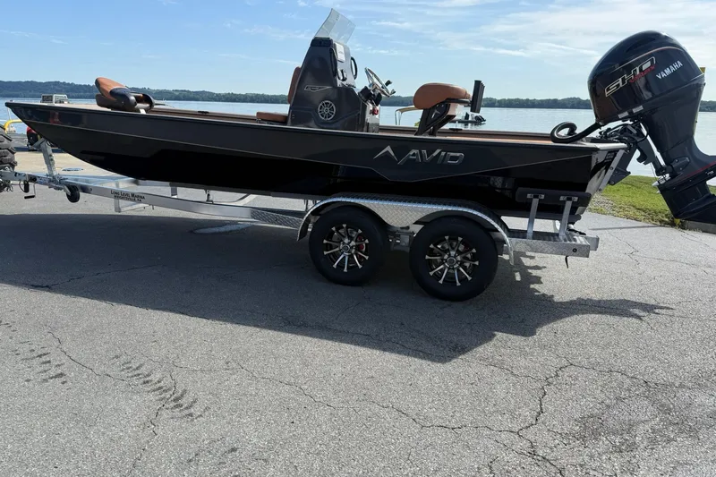 Slide: The Image of Avid 207 Recon boat on trailer, featuring Yamaha engine, parked by a lake, 2027 model. - 3