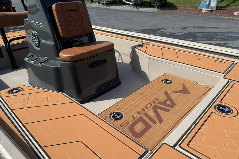 Slide: The Image of 2027 Avid 207 Recon boat interior with tan seating and deck, featuring Avid branding. - 10