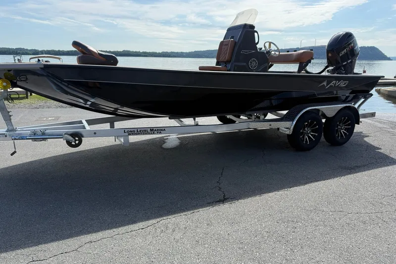 Slide: The Image of Avid 207 Recon boat on trailer at marina, 2027 model, lakeside view. - 2