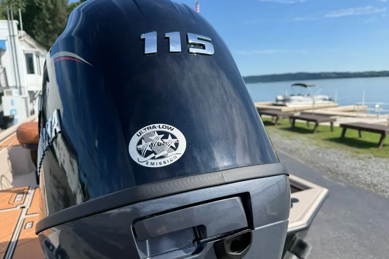 Slide: The Image of Outboard motor with "115" label and ultra-low emission sticker, near a lakeside dock. - 6