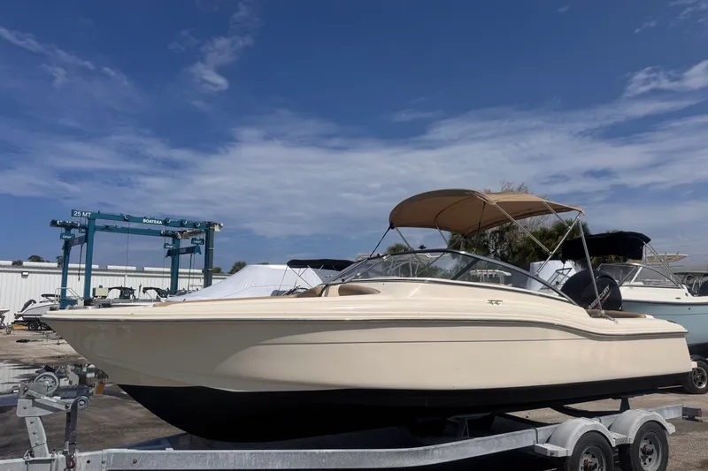 The Image of 2023 Scout 210 Dorado boat on trailer under clear blue sky. - 1
