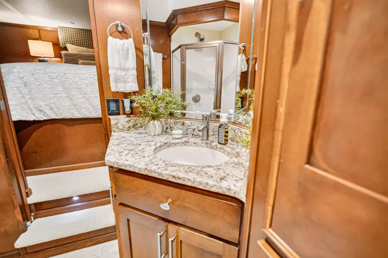 Slide: The Image of Luxurious bathroom in 2011 STARDUST 18 x 85 houseboat with granite countertop and wooden cabinetry. - 17