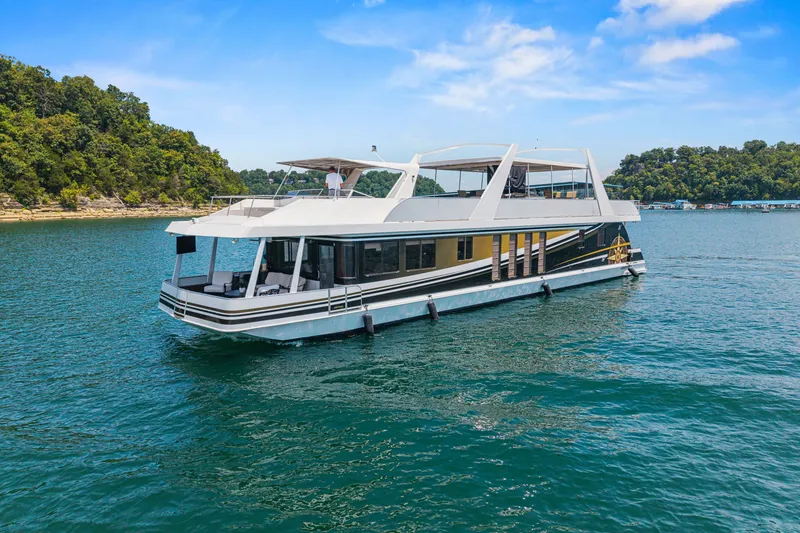 The Image of Houseboat on serene lake, STARDUST 18 x 85, 2011 model, under clear blue sky. - 1