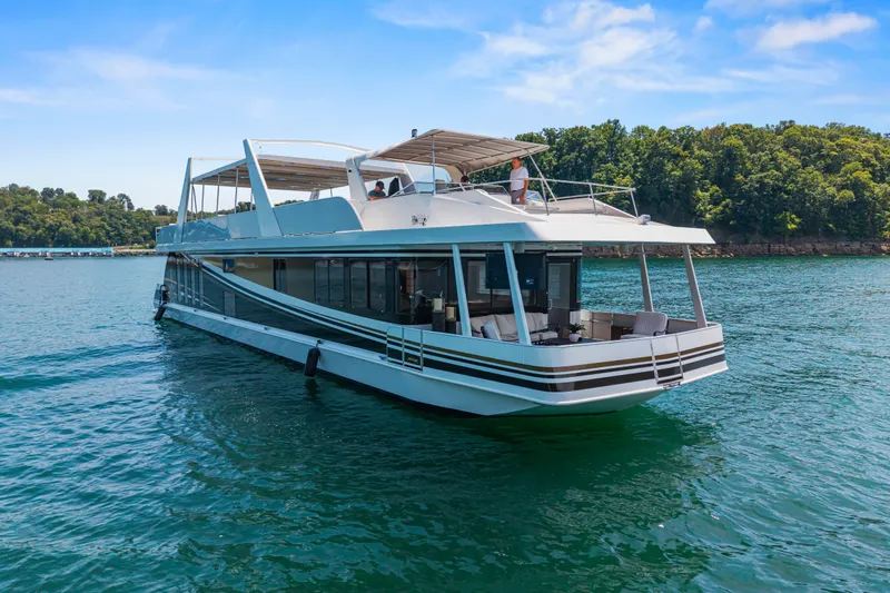 Slide: The Image of Luxurious 2011 STARDUST 18 x 85 houseboat cruising on a serene lake under a clear blue sky. - 4