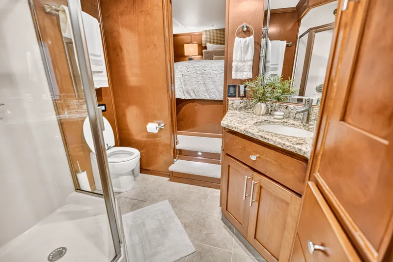Slide: The Image of Luxurious bathroom in 2011 STARDUST 18 x 85 houseboat with granite countertop and wooden cabinetry. - 16