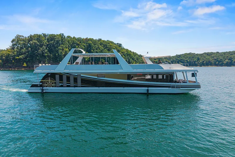 Slide: The Image of Luxurious 2011 STARDUST 18 x 85 houseboat cruising on a serene lake under a clear sky. - 5