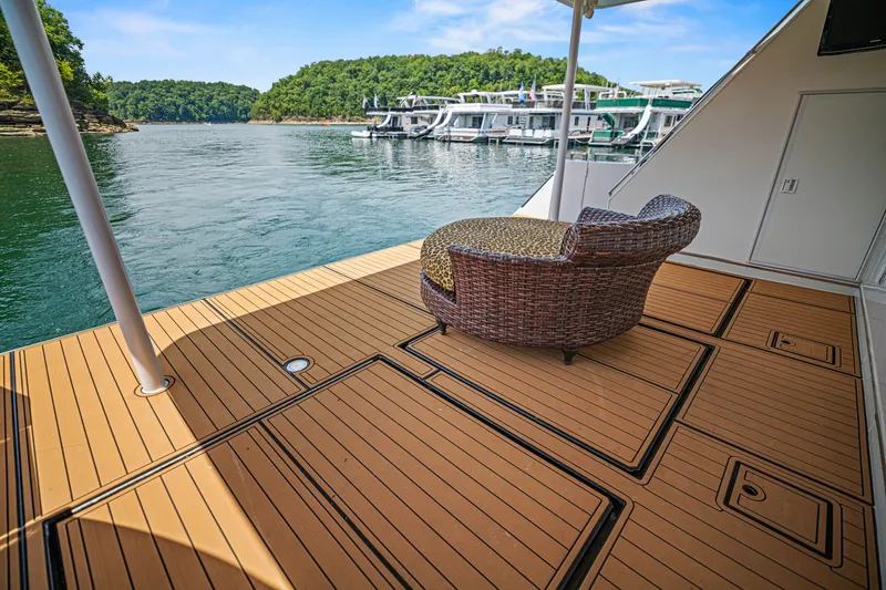 Slide: The Image of Luxury houseboat deck with wicker chair, overlooking serene lake and docked boats. STARDUST 18 x 85, 2011. - 22