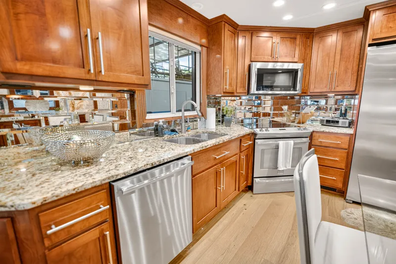Slide: The Image of Modern kitchen with wooden cabinets, granite countertops, and stainless steel appliances in a 2011 STARDUST model. - 12