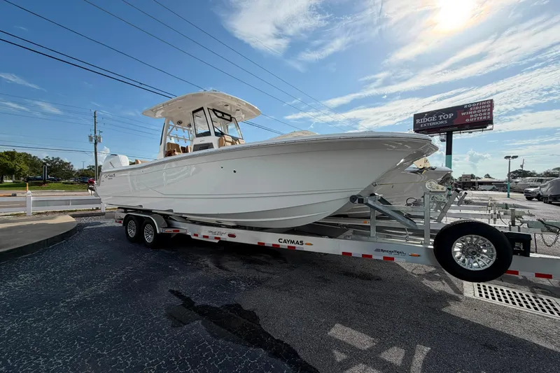 Slide: The Image of 2027 Caymas 29 CT boat on trailer under clear sky, parked outdoors. - 2