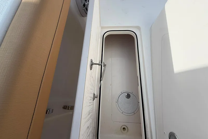 Slide: The Image of Storage compartment of 2027 Caymas 29 CT boat, featuring a secure latch and drainage system. - 17