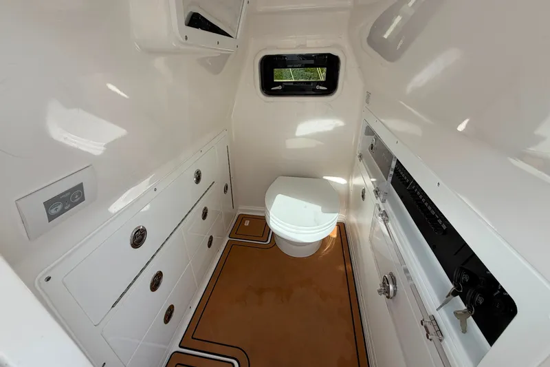 Slide: The Image of Interior of 2027 Caymas 29 CT boat featuring a compact, modern bathroom with storage. - 15