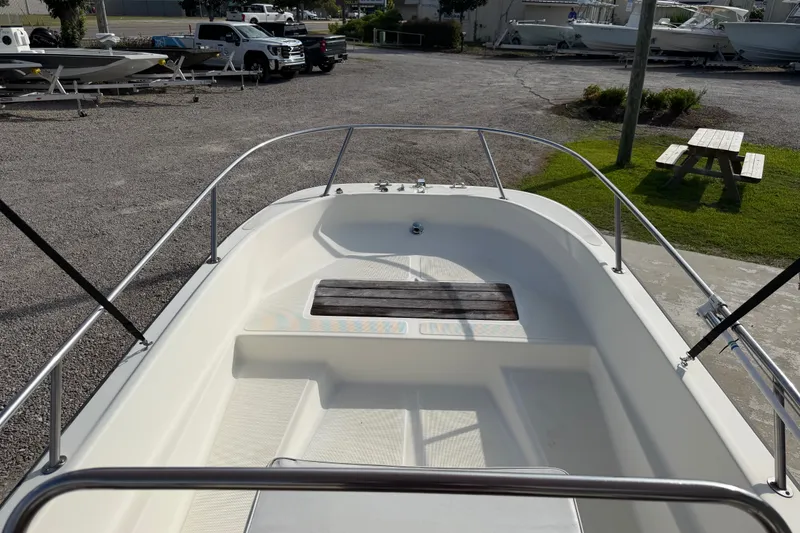 Slide: The Image of 1988 Wahoo 1850 boat interior with railing, parked outdoors on gravel. - 14