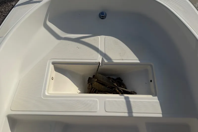 Slide: The Image of Interior view of a 1988 Wahoo 1850 boat showing storage compartment with anchor and rope. - 15