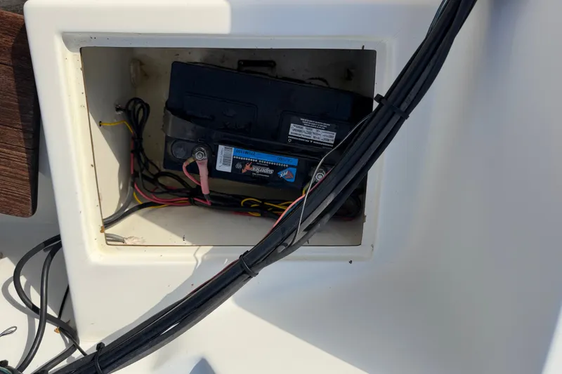 Slide: The Image of Battery compartment of a 1988 Wahoo 1850 boat, showing wiring and connections. - 22