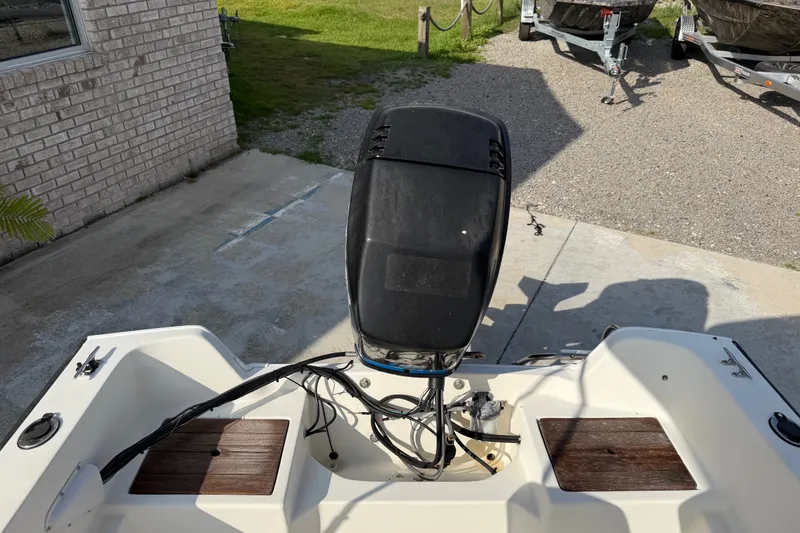 Slide: The Image of 1988 Wahoo 1850 boat with outboard motor, parked on concrete near trailers. - 20