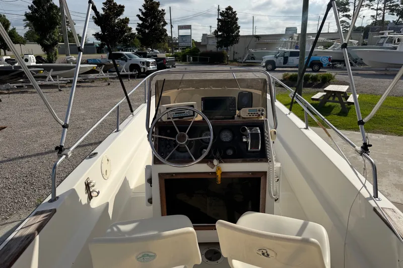 Slide: The Image of 1988 Wahoo 1850 boat interior with steering wheel and dashboard controls. - 16