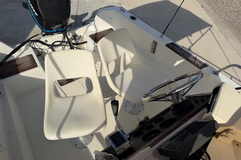 Slide: The Image of Interior of a 1988 Wahoo 1850 boat with steering wheel and seating. - 17