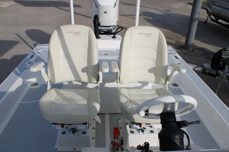 Slide: The Image of 2025 Mamba 24 Cat Elite boat interior with dual white captain seats and steering wheel. - 14