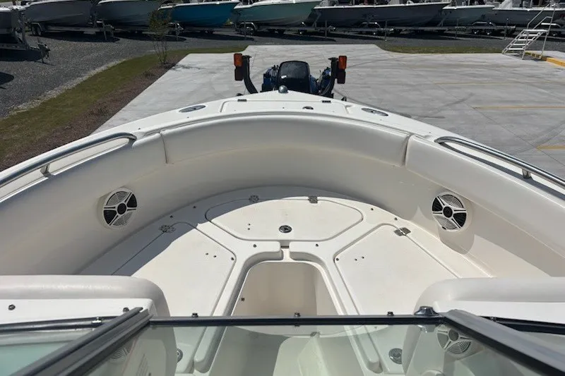 Slide: The Image of 2009 Robalo R227 Dual Console boat interior with seating and speakers, parked in a marina. - 14