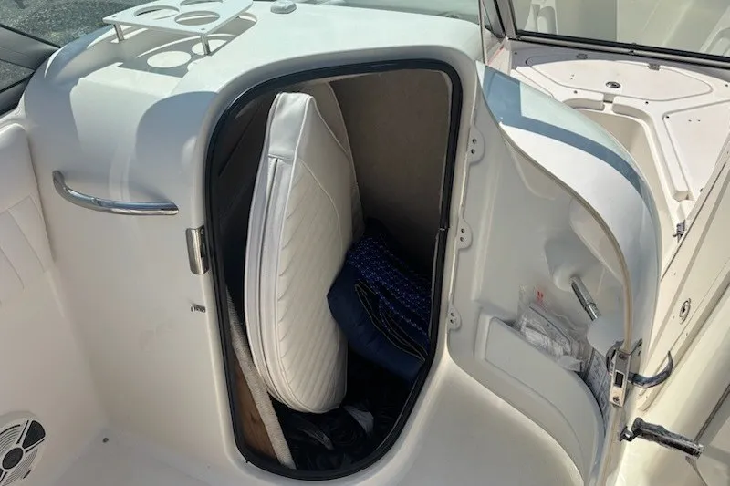 Slide: The Image of Storage compartment on a 2009 Robalo R227 Dual Console boat with cushions inside. - 15