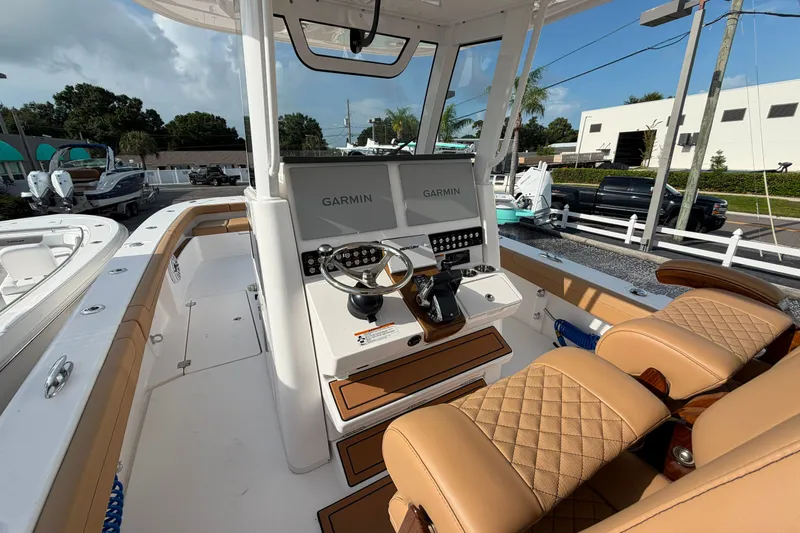 Slide: The Image of 2027 Caymas 29 CT boat cockpit with Garmin navigation, luxurious seating, and modern controls. - 8