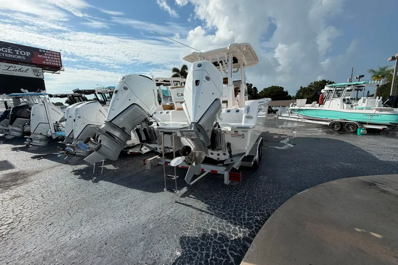 Slide: The Image of 2027 Caymas 29 CT boat with dual outboard motors on display in a dealership lot. - 11