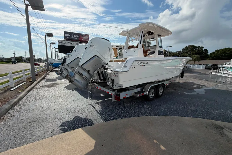 Slide: The Image of 2027 Caymas 29 CT boat on trailer with dual outboard motors, parked outdoors. - 3