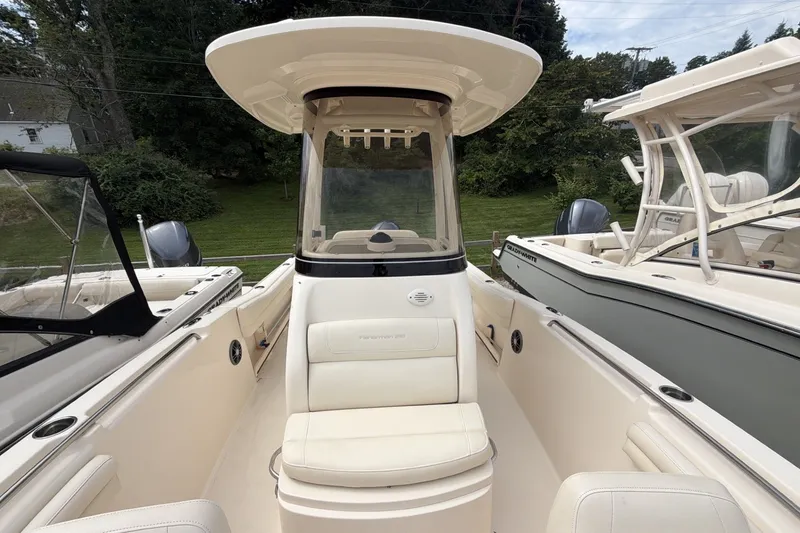 Slide: The Image of 2023 Grady-White Fisherman 216 boat interior with seating and console, docked outdoors. - 10