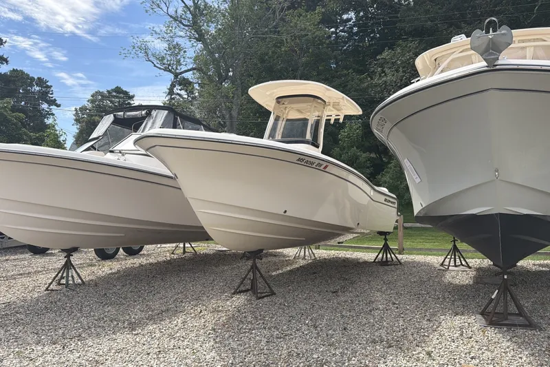 Slide: The Image of 2023 Grady-White Fisherman 216 boats displayed on stands outdoors. - 2