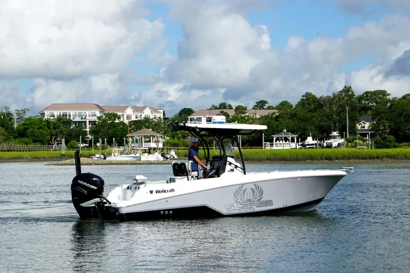 Slide: The Image of 2022 Wellcraft 242 Scarab Offshore boat cruising on a scenic waterway. - 5