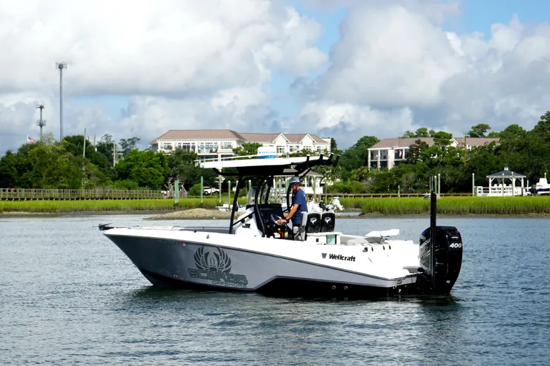 Slide: The Image of 2022 Wellcraft 242 Scarab Offshore boat cruising on a scenic waterway. - 2