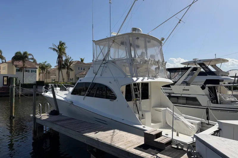Slide: The Image of 1996 Post 46 Convertible yacht docked at marina, surrounded by palm trees and waterfront homes. - 1