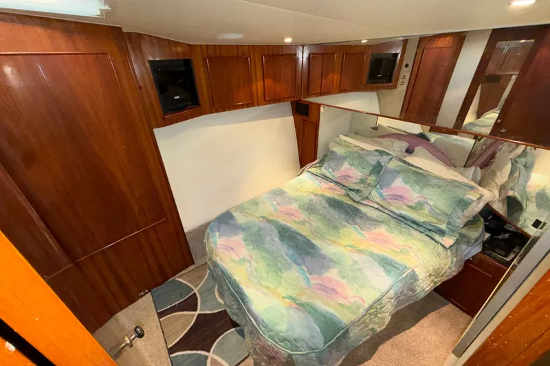 Slide: The Image of Cozy bedroom in 1996 Post 46 Convertible yacht with wood paneling and colorful bedding. - 20
