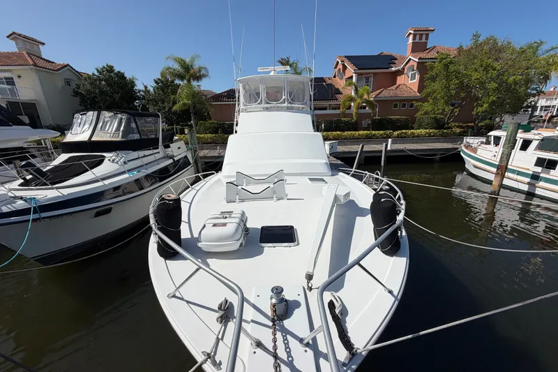 Slide: The Image of 1996 Post 46 Convertible yacht docked in marina, surrounded by other boats and waterfront homes. - 4