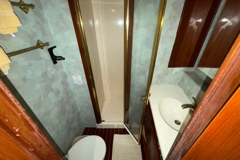 Slide: The Image of Bathroom interior of a 1996 Post 46 Convertible yacht, featuring shower, sink, and toilet. - 23