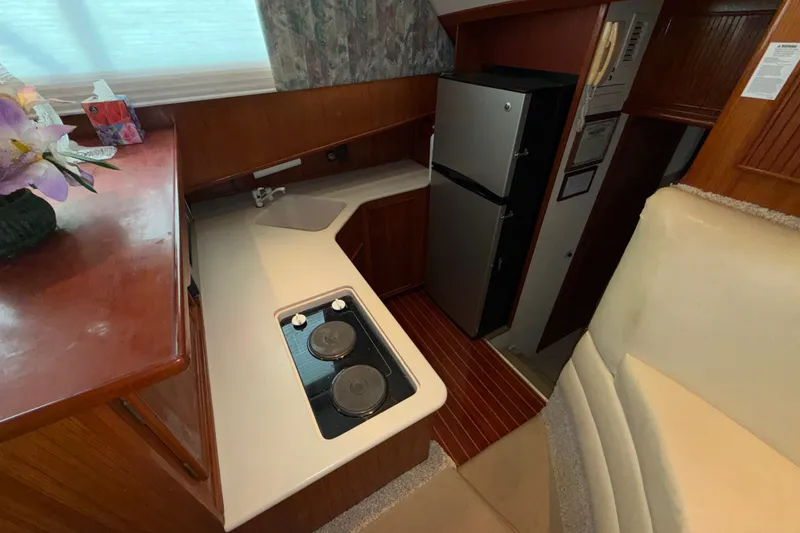Slide: The Image of Compact kitchen area in a 1996 Post 46 Convertible yacht, featuring stove and refrigerator. - 17