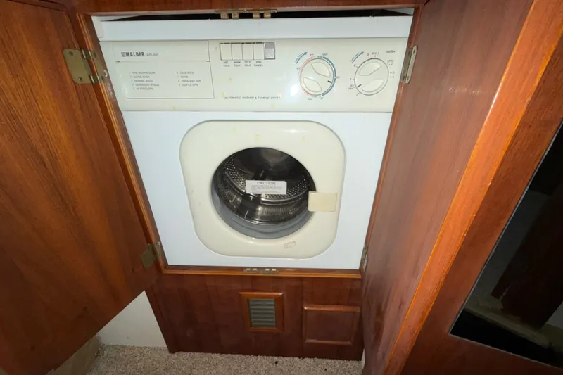 Slide: The Image of Washer-dryer unit in wooden cabinet on a 1996 Post 46 Convertible boat. - 19