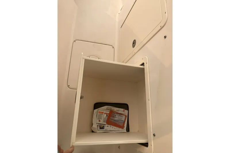 Slide: The Image of Storage compartment on a 2008 Grady White 275 Tournament boat, containing various items. - 14