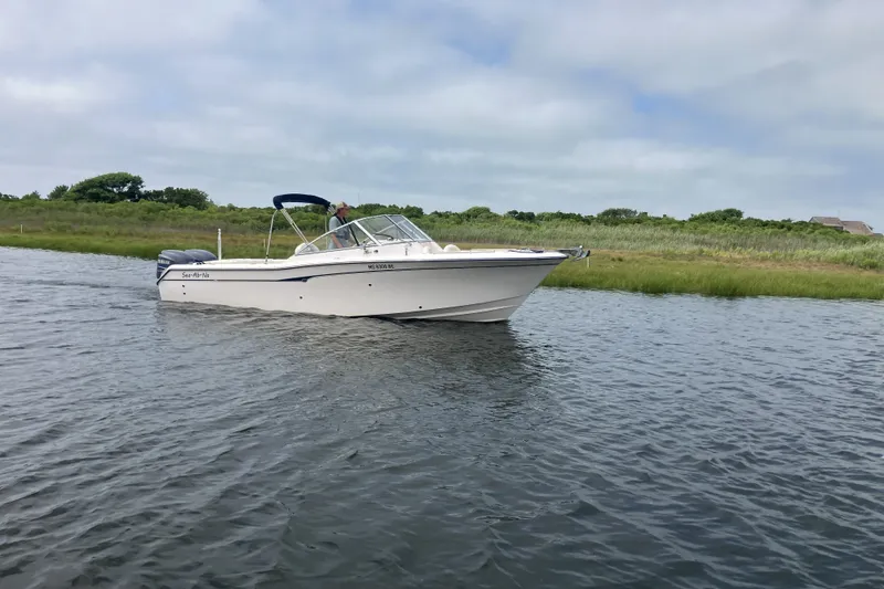 Slide: The Image of 2008 Grady White 275 Tournament boat cruising on a calm river with grassy banks. - 4