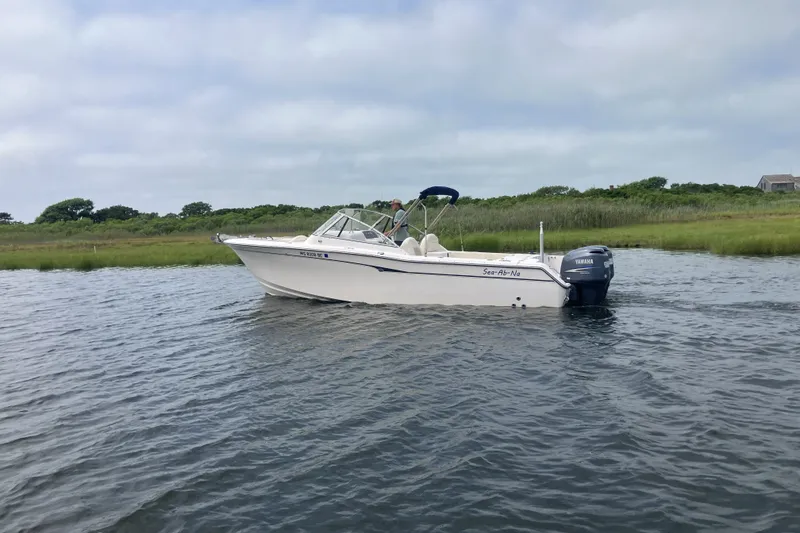 Slide: The Image of 2008 Grady White 275 Tournament boat on calm water near grassy shoreline. - 3